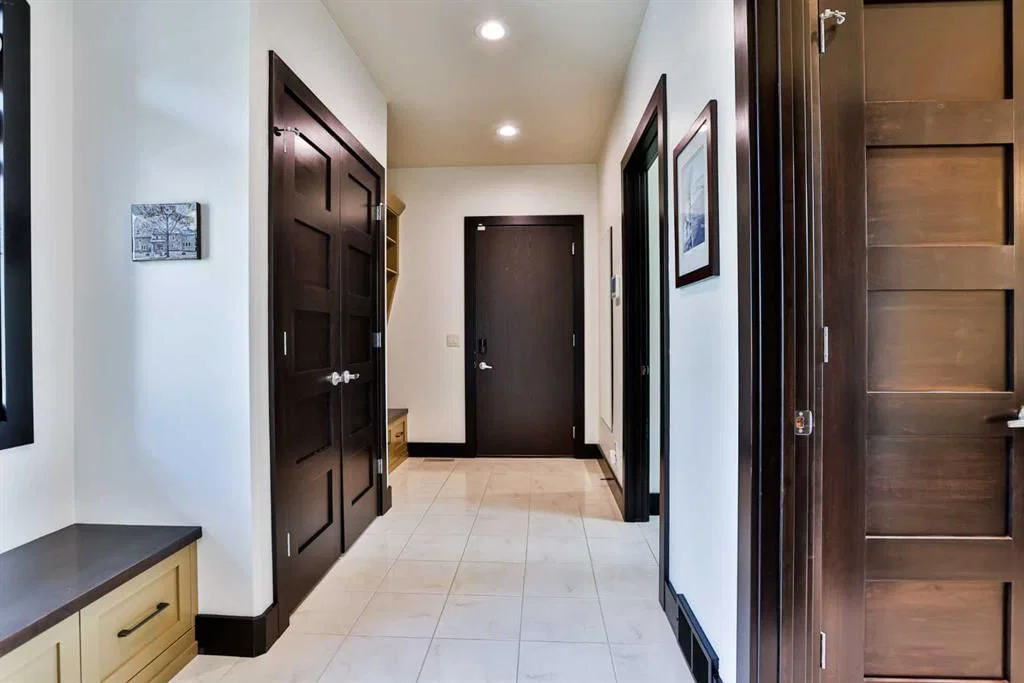 Homes back entry storage system with dark wood finishes and light ceramic tile