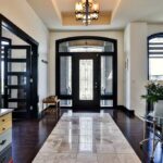 Grand entrance with dark wood detailing, wooden floors and onyx tile
