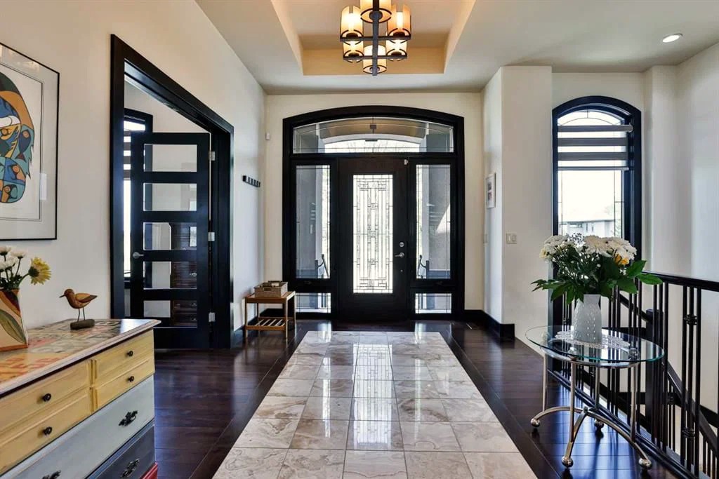 Grand entrance with dark wood detailing, wooden floors and onyx tile