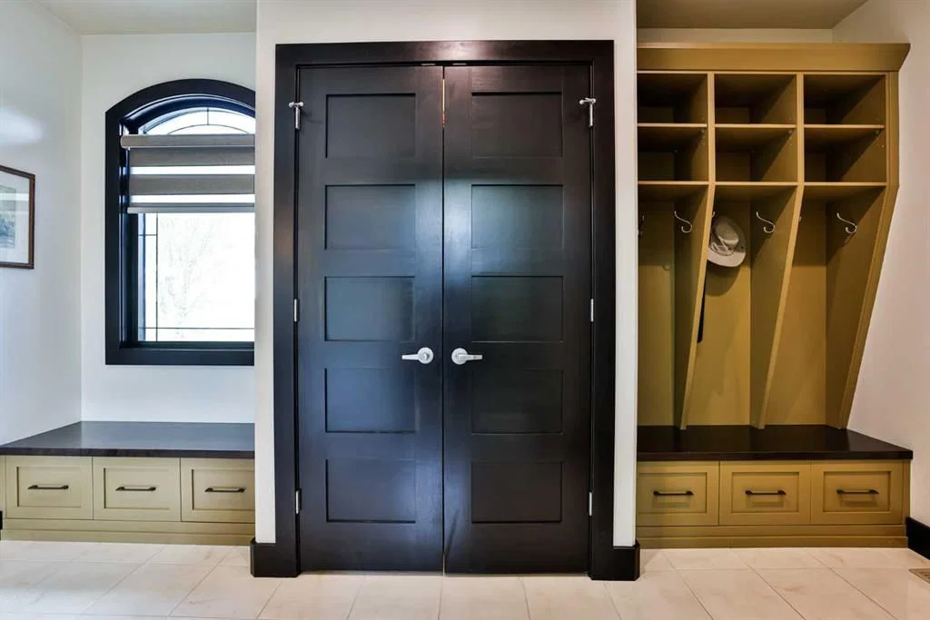 Homes back entry storage system with dark wood finishes and light ceramic tile