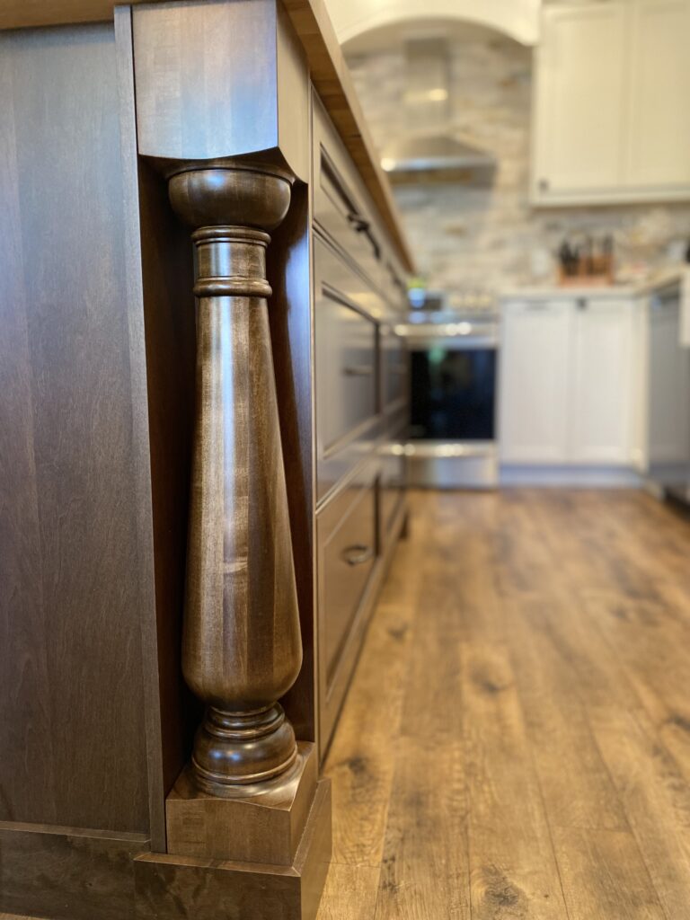 Wooden kitchen island with ornate column detail.