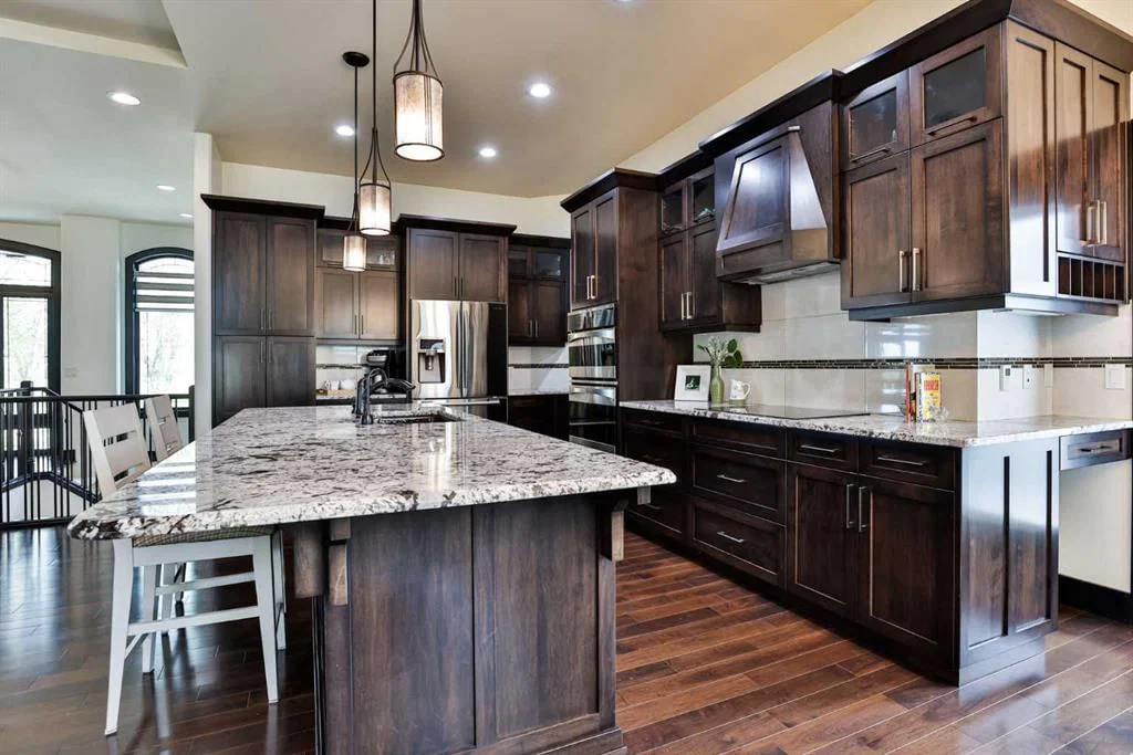 Luxury residential kitchen design with espresso cabinetry, granite counter-tops and oil rubber bronze fixtures