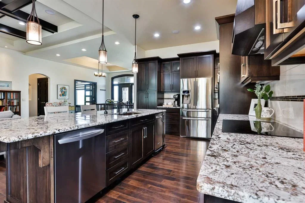 Luxury residential kitchen design with espresso cabinetry, granite counter-tops and oil rubber bronze fixtures